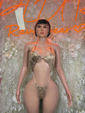 Tan metallic one-piece slingshot bodysuit with halter straps and high-cut front