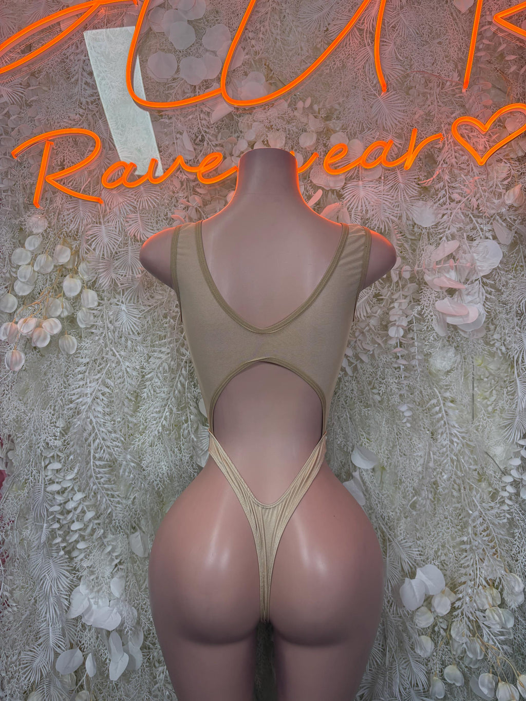 Nude halter bodysuit with open back and thong-style leg openings