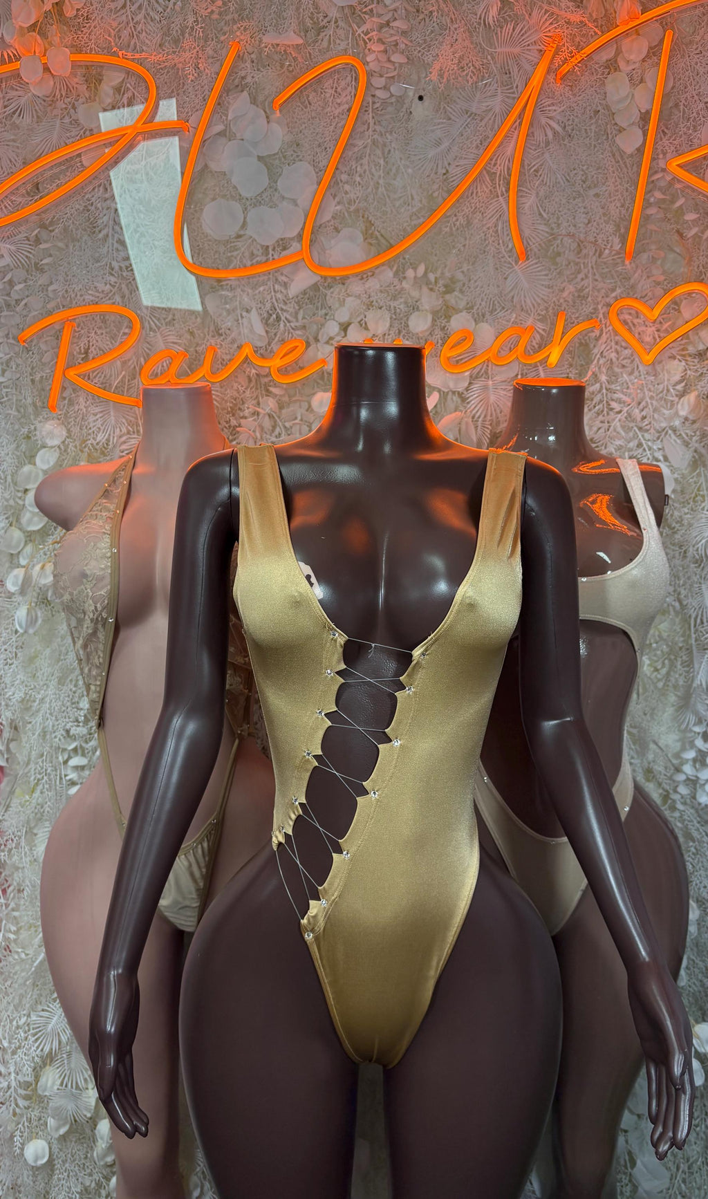 Gold one-piece bodysuit with plunging neckline and decorative lace-up panel
