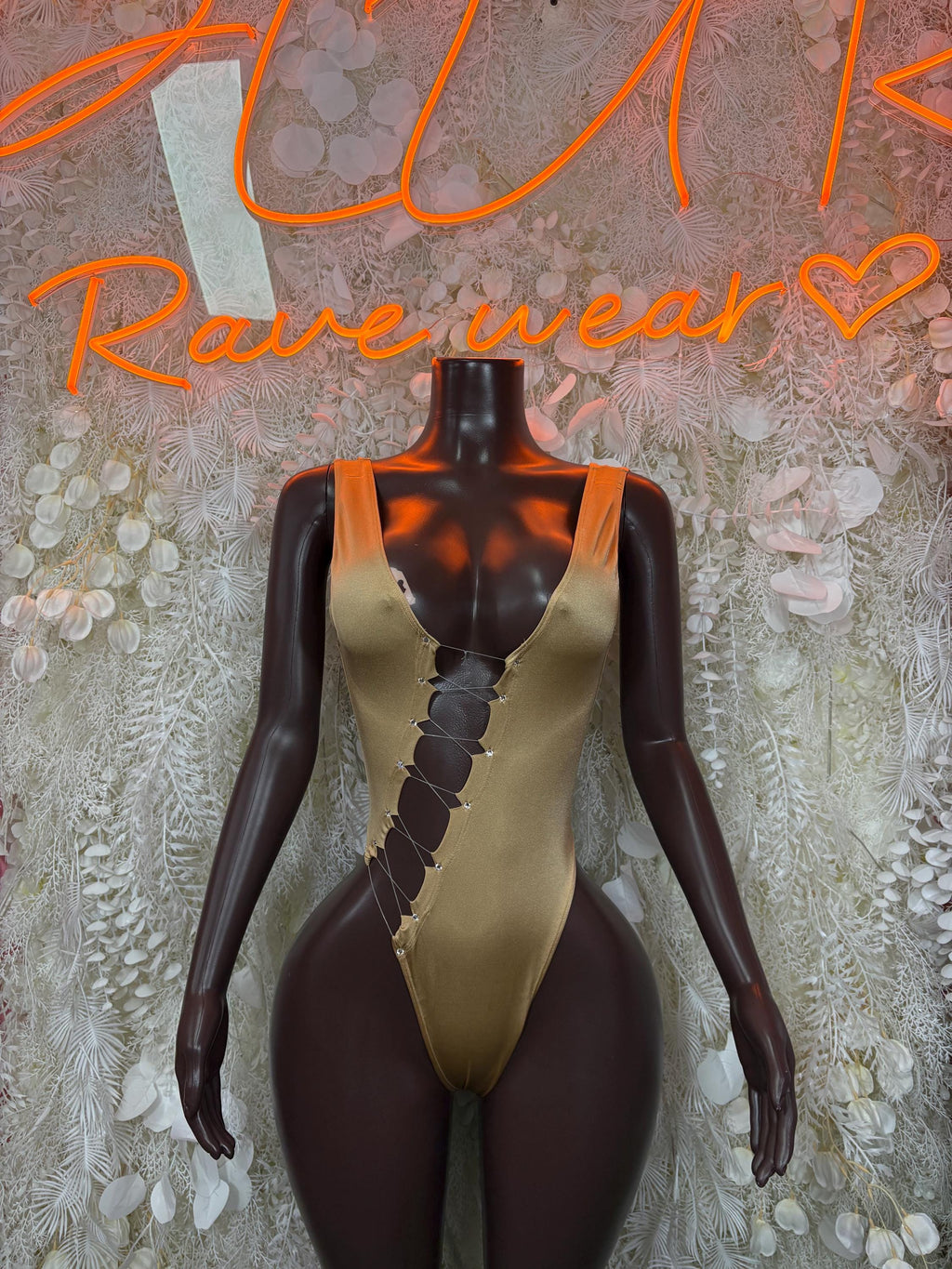 Gold one-piece bodysuit with plunging V neckline and lace-up front detail