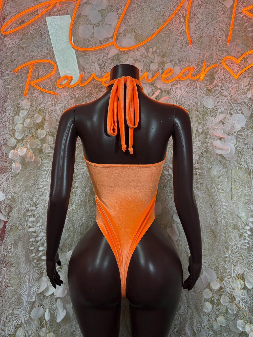 Orange halter bodysuit with high-cut legs and tied racer-back neck detail