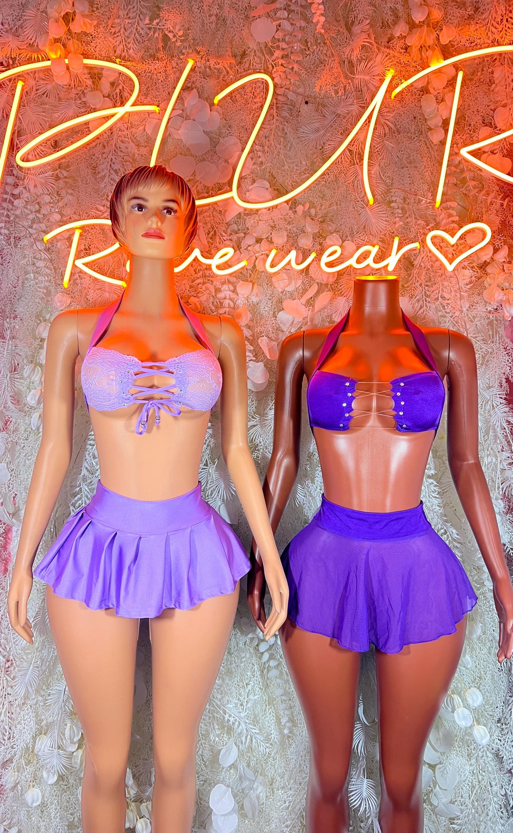 Purple two-piece rave outfit on two models: sparkly bandeau top and pleated mini skirt