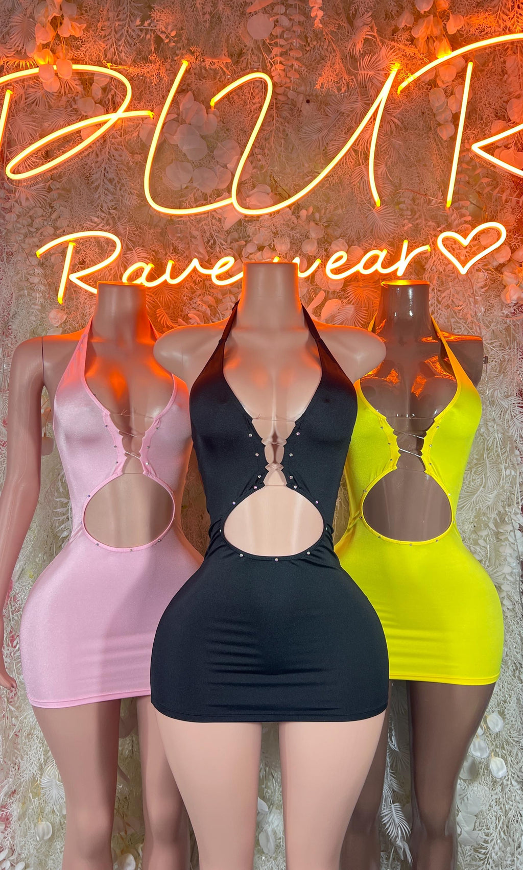 Three mini bodycon club dresses: pink, black, and neon yellow with oval cutouts