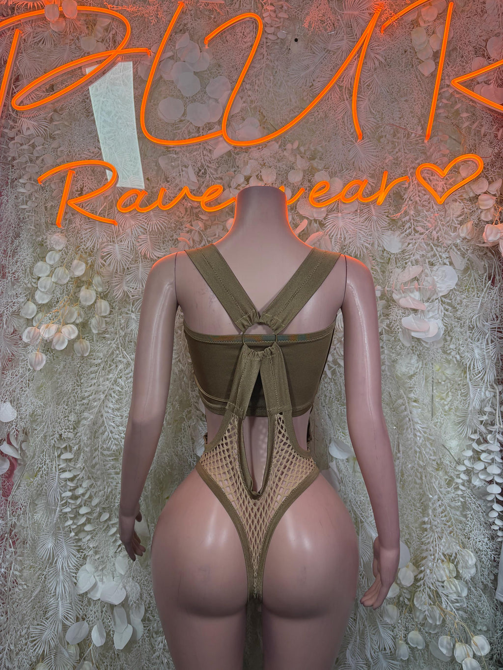 Tan fishnet bodysuit with cross straps, deep V neckline, and cheeky coverage