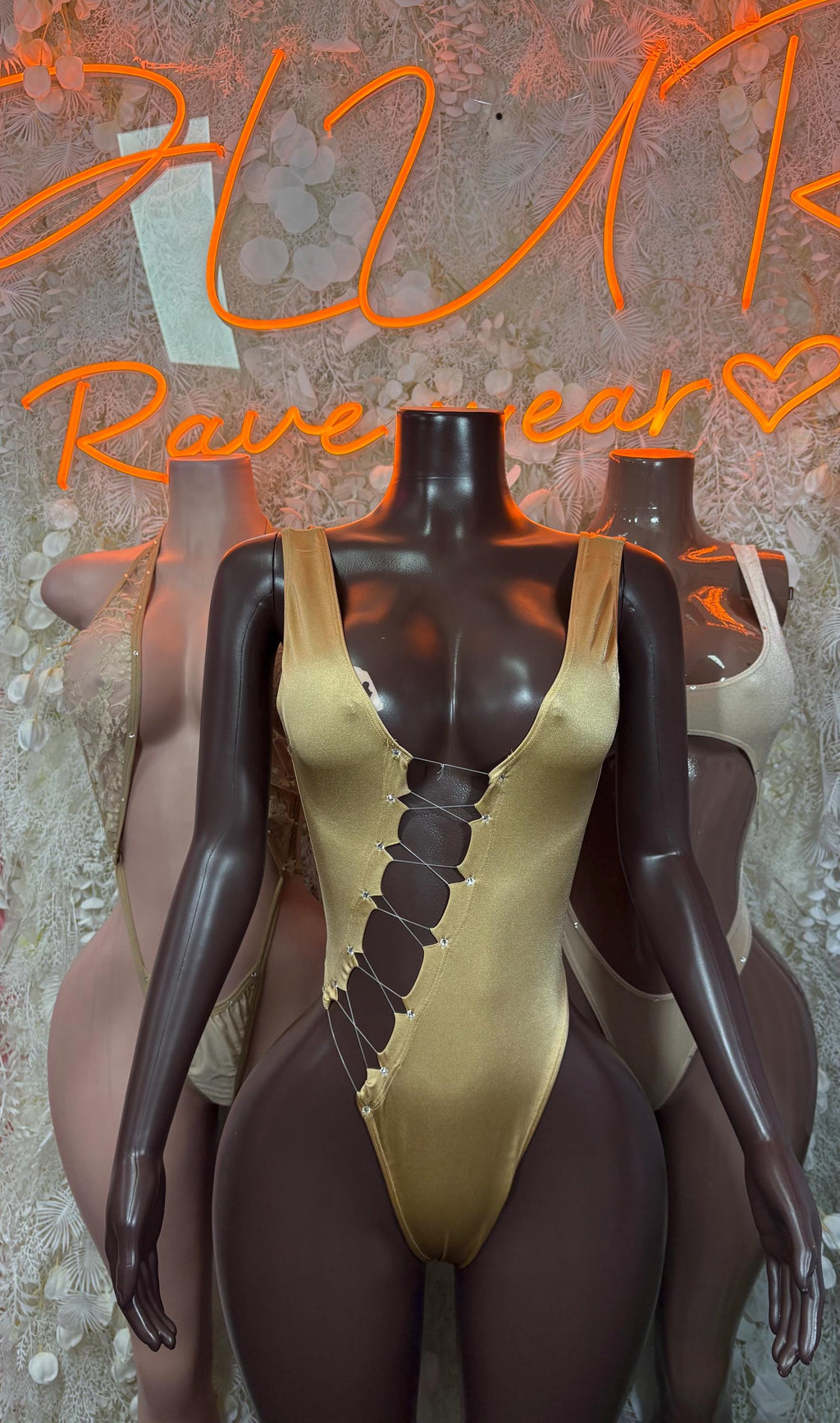 Tan dancewear bodysuit with gold-tone trim and front lace-up V detail