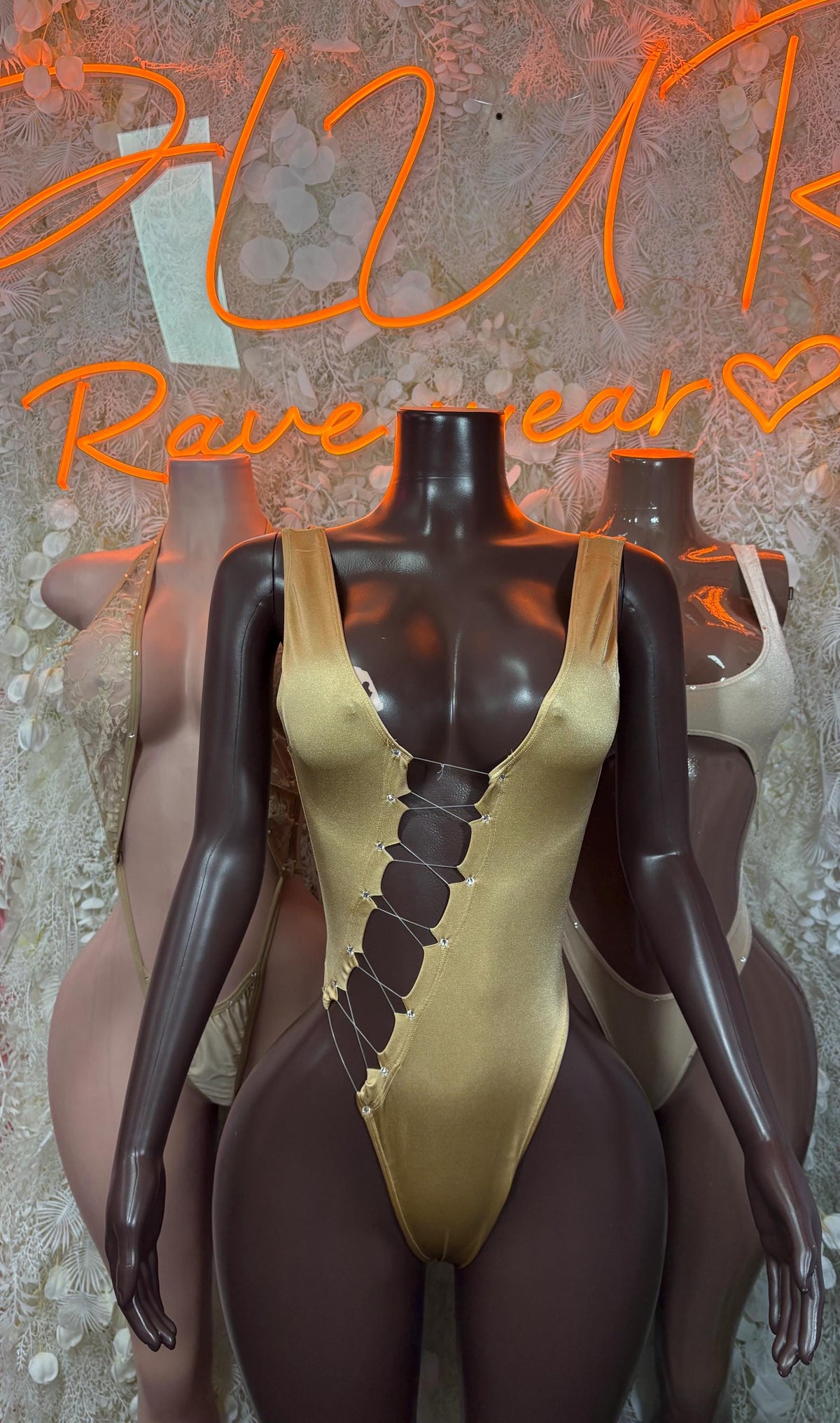 Tan dancewear bodysuit with gold-tone trim and front lace-up V detail