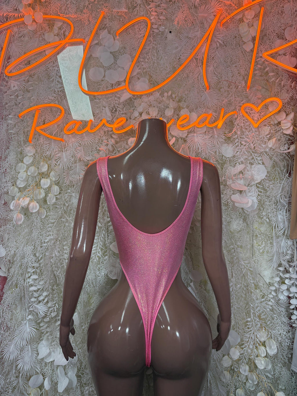 Pink glitter one-piece bodysuit with open-back cut and high-leg fit
