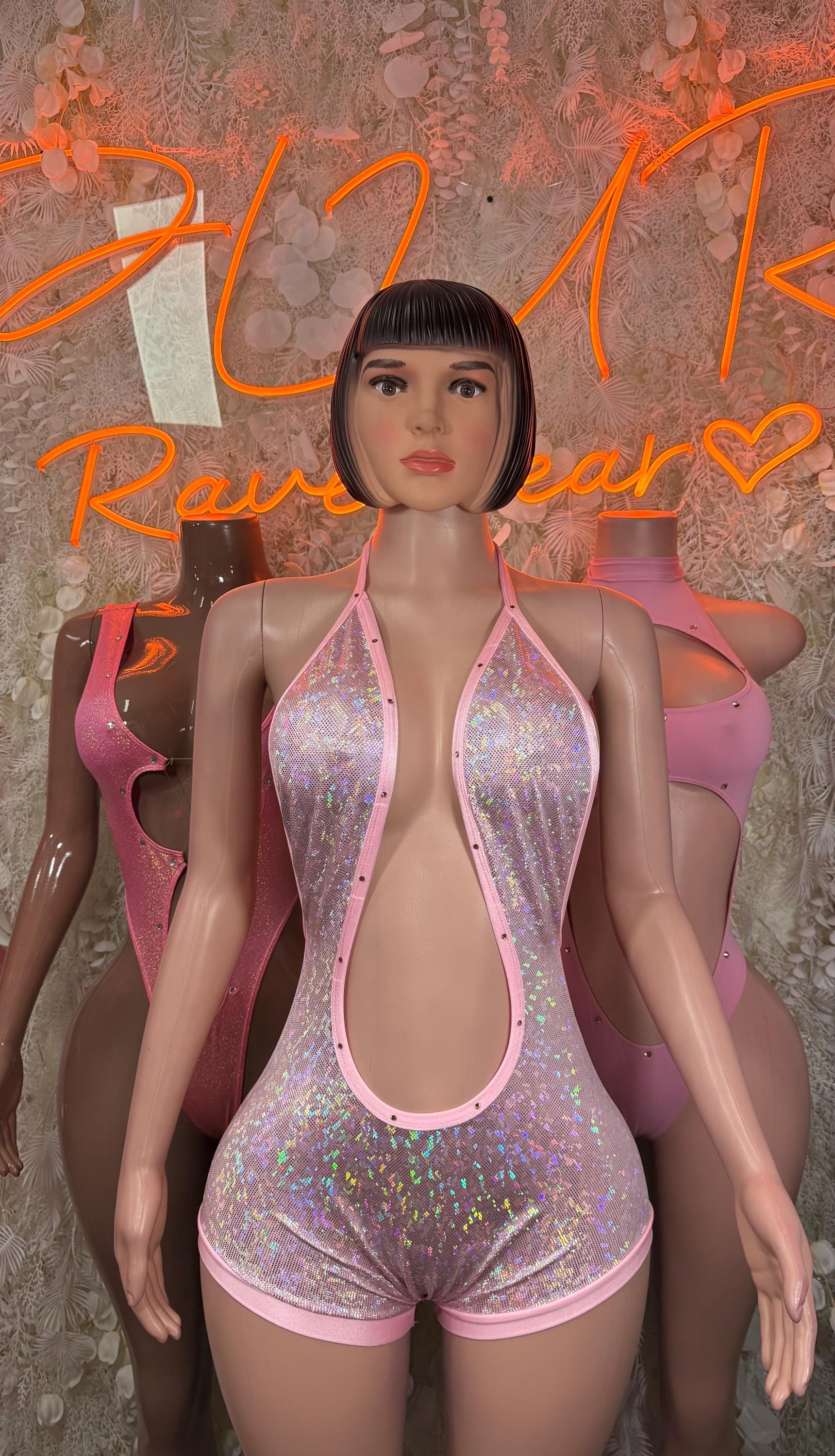 Pink holographic halter bodysuit with deep oval front cutout and minimal shorts