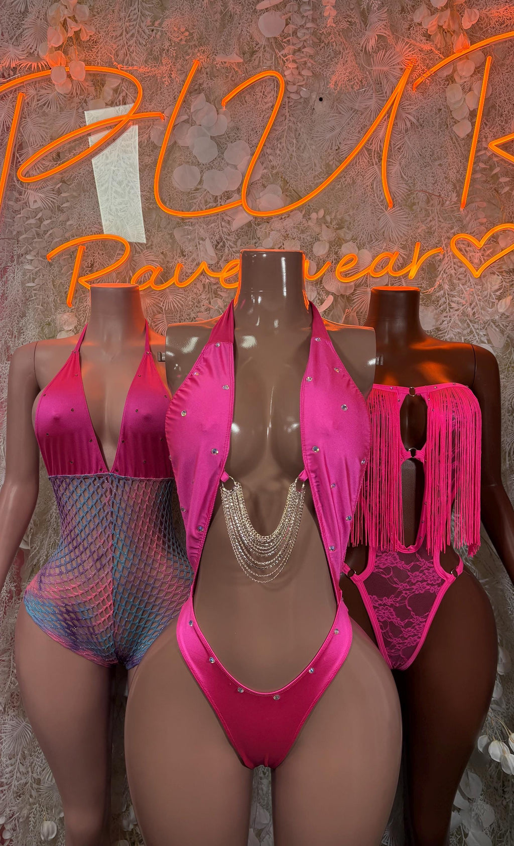 Pink fringe bodysuits on three mannequins, one-piece with V-cut and tassels