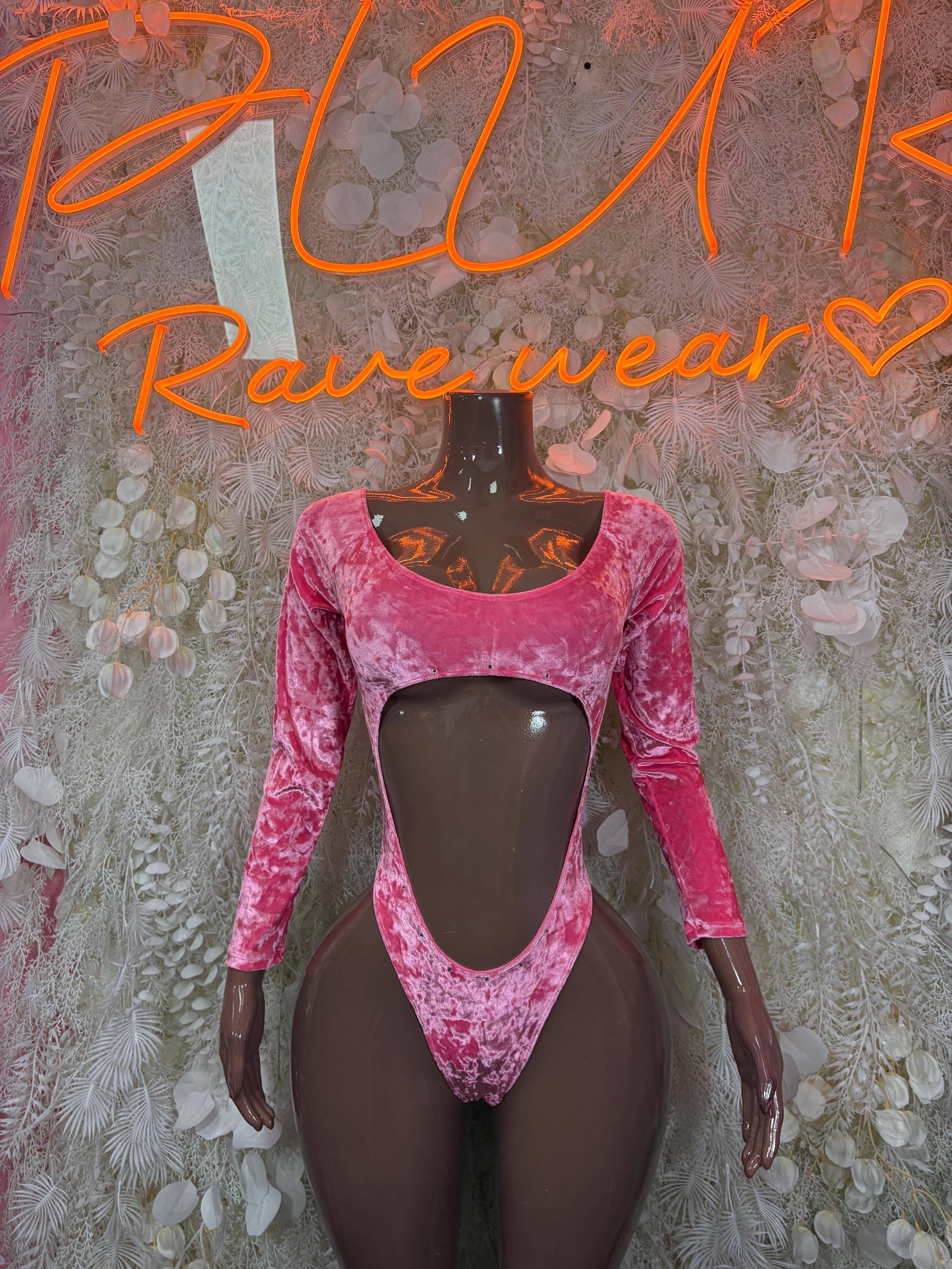 Pink velvet bodysuit with long sleeves and deep V front cutout on mannequin