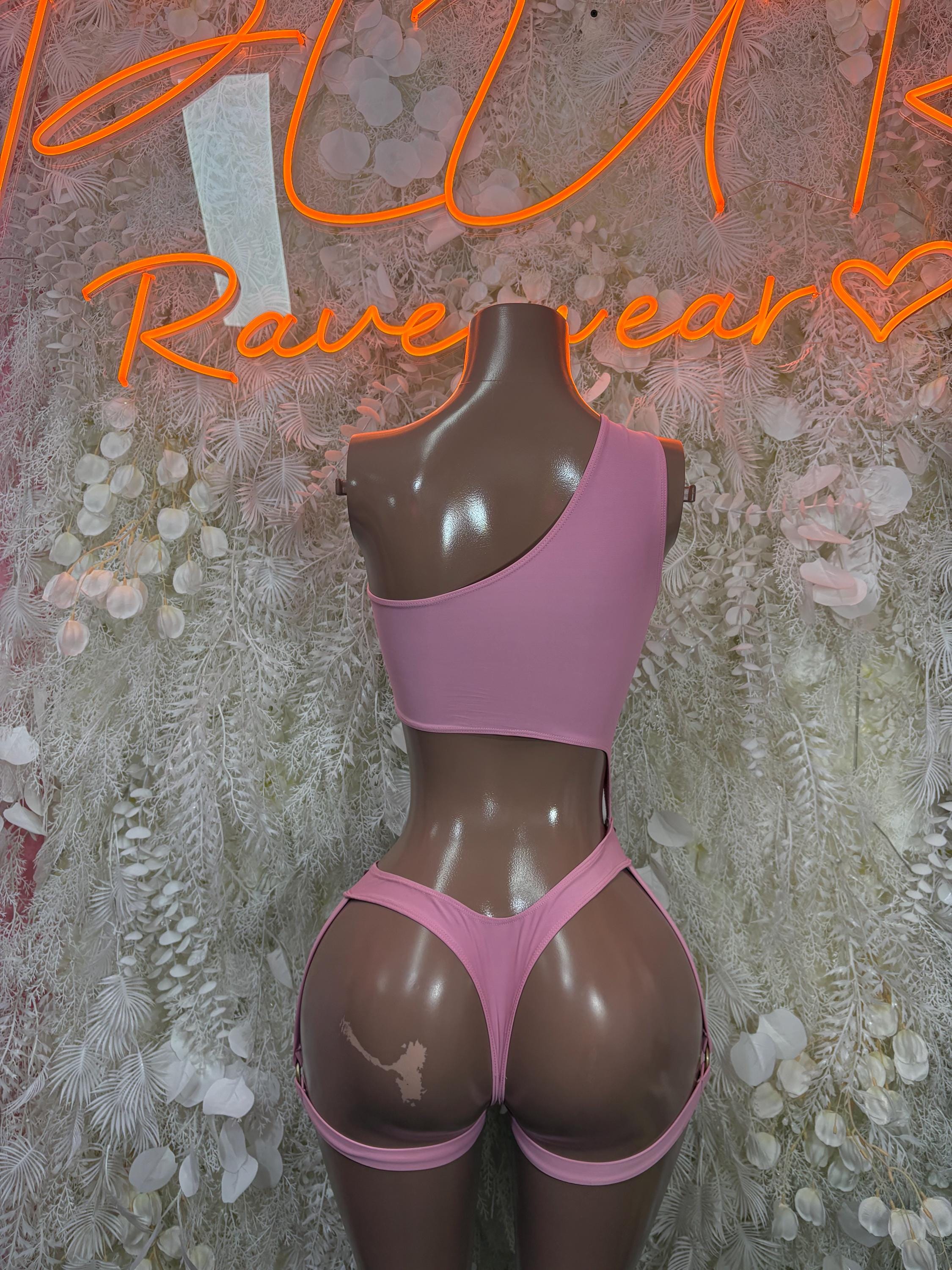 Pink strappy festival bodysuit with open back and low-rise thong bottoms.