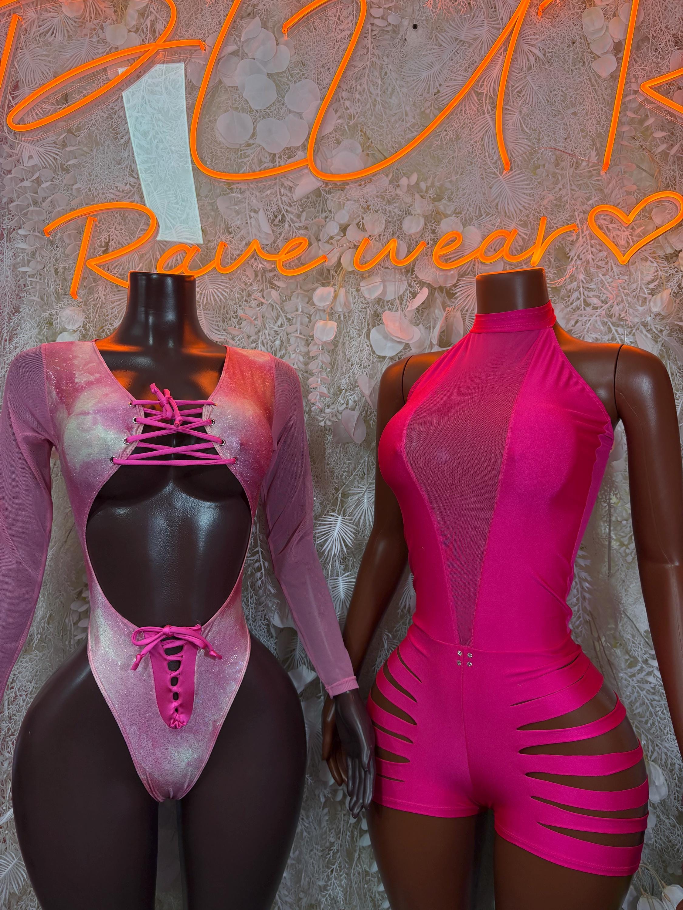Two festival bodysuits: metallic pink long-sleeve lace-up and hot pink cutout romper