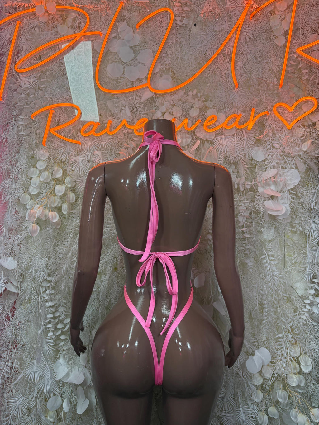 Pink halter one-piece bodysuit with back tie straps and high-cut legs