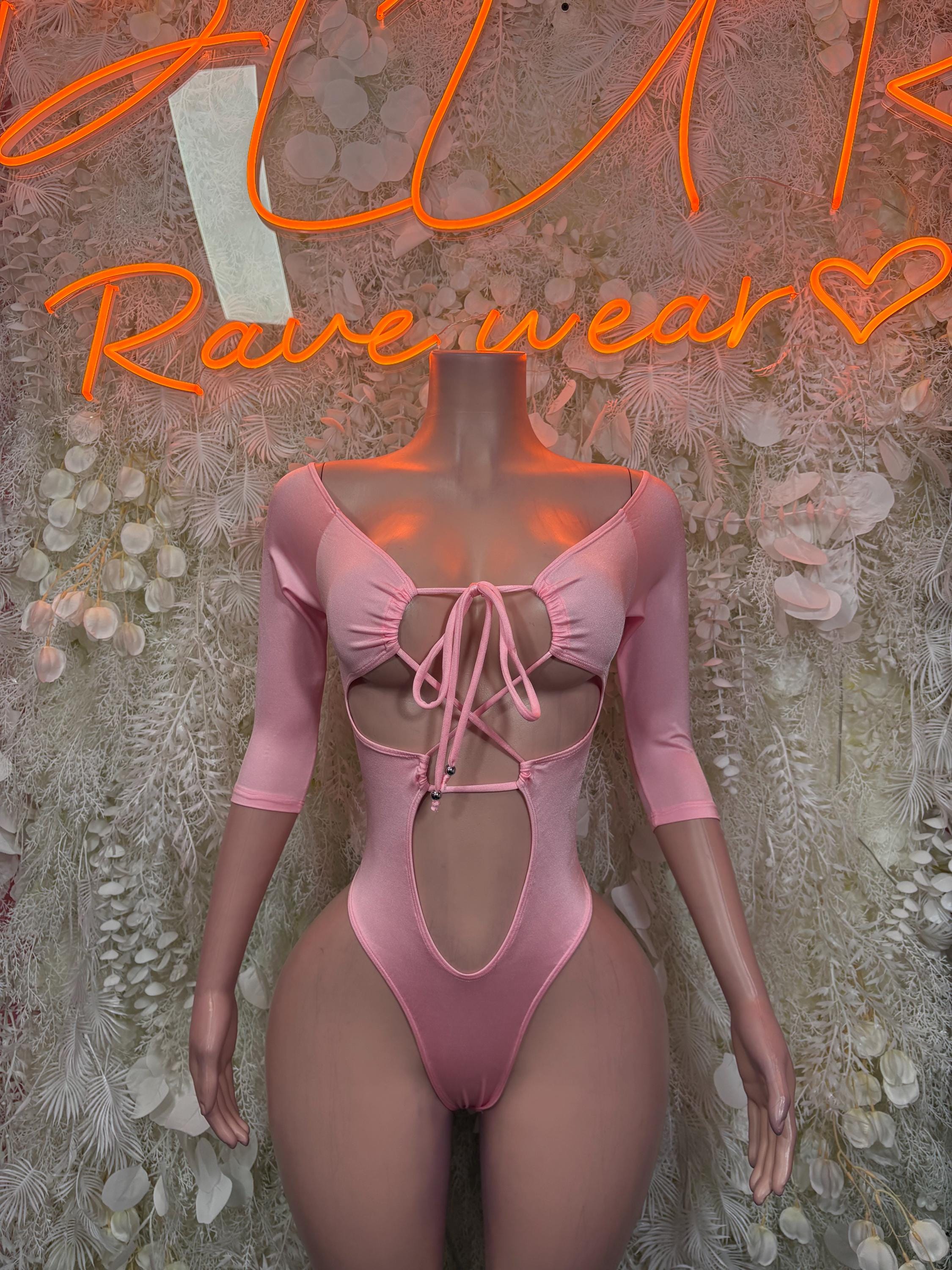 Pink one-piece bodysuit with long sleeves, lace-up front and bow detail