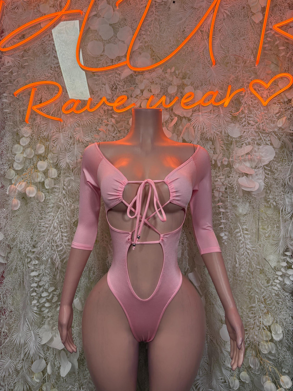 Pink one-piece bodysuit with front lace-up bow and long sleeves