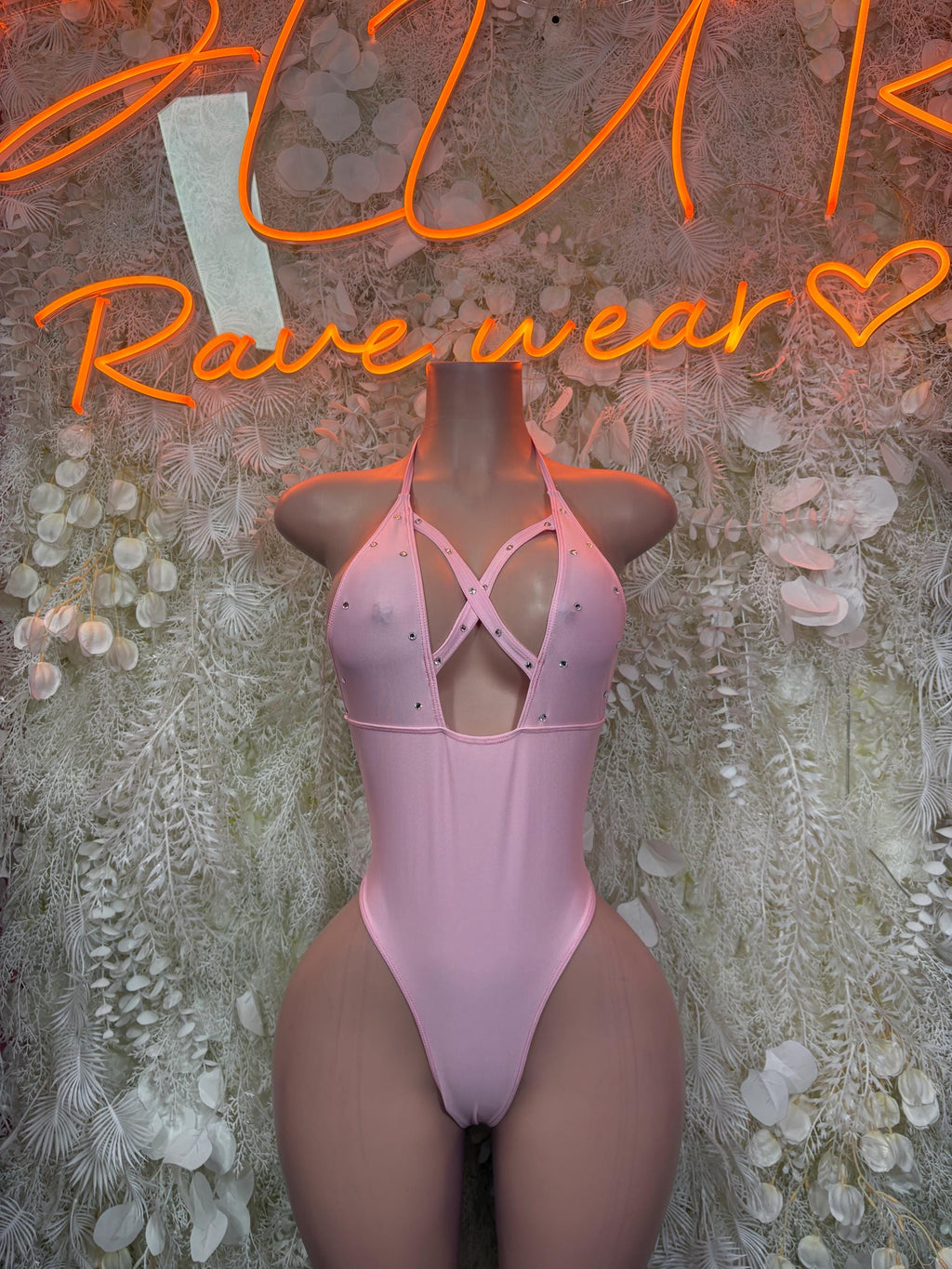 Pink one-piece bodysuit with crisscross open back and high-cut legs