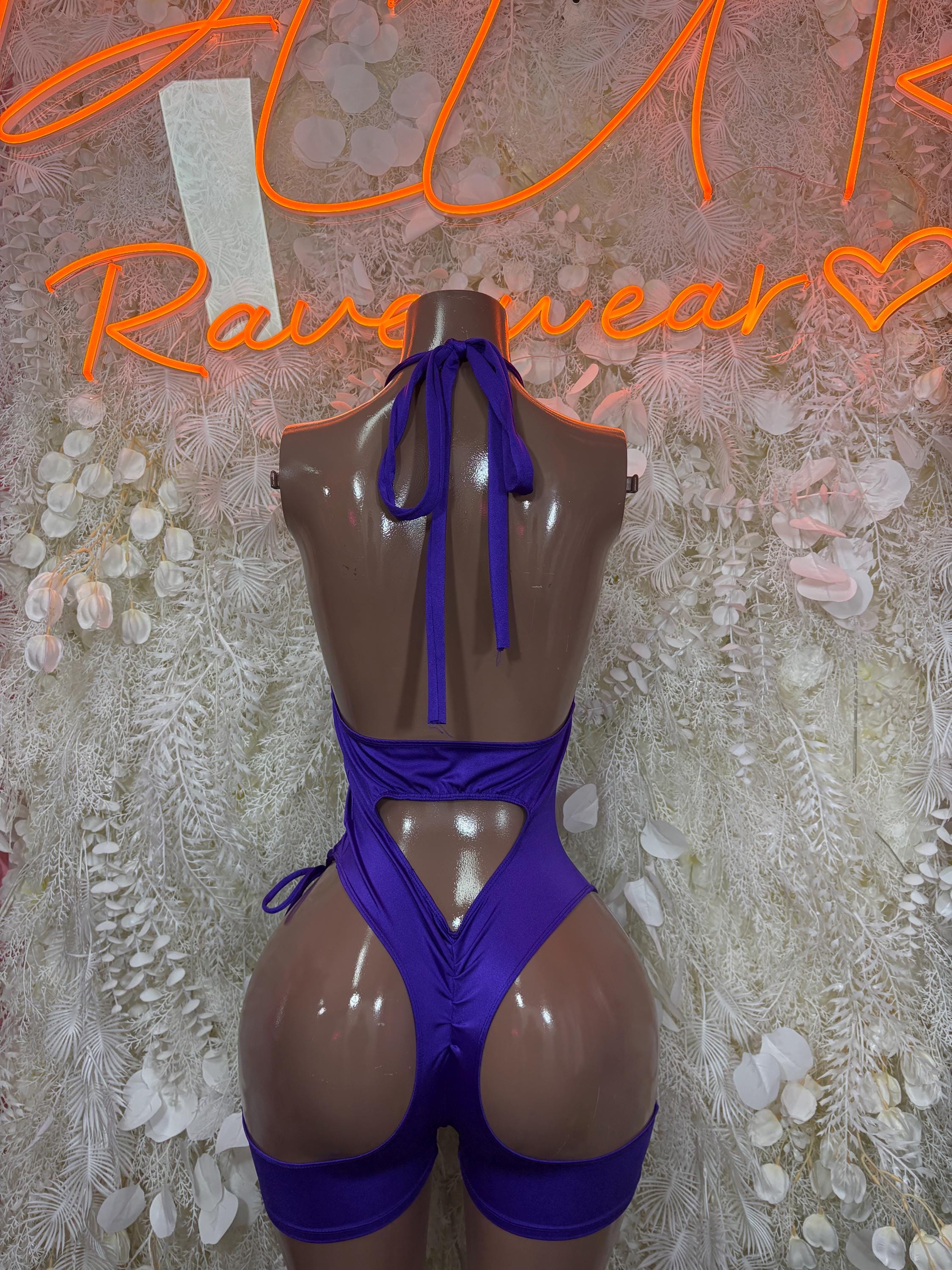 Purple dancewear playsuit with open back, tie straps, and ruched hip cutouts