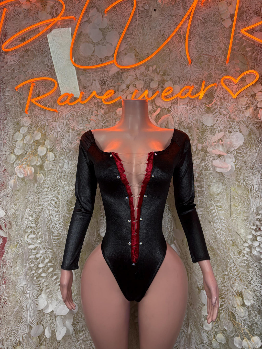 Black long-sleeve bodysuit with deep V neckline and red center trim
