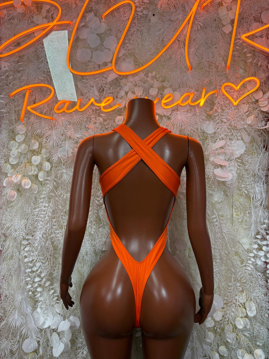 Orange one-piece bodysuit with crisscross back straps and high-cut back
