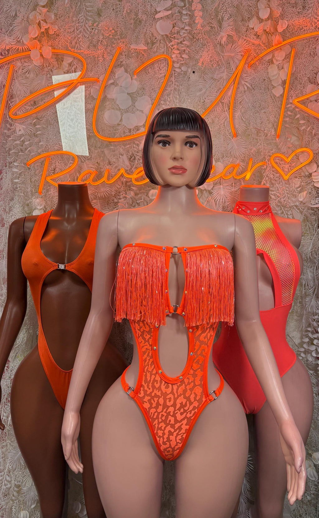 Orange one-piece bodysuit with fringe bust detail and scoop front cutout