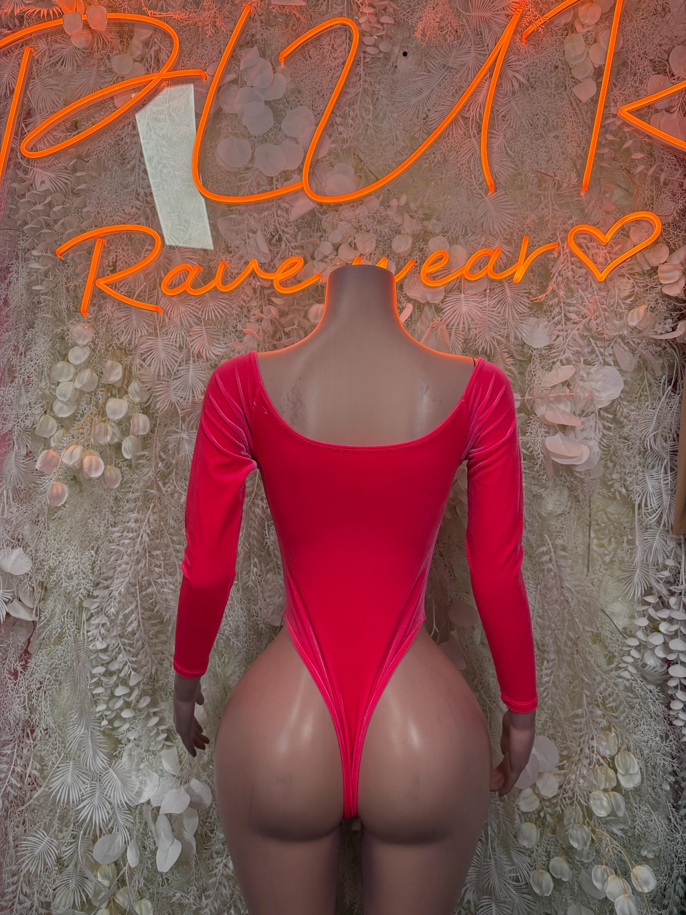 Pink one-piece bodysuit with long sleeves and open back