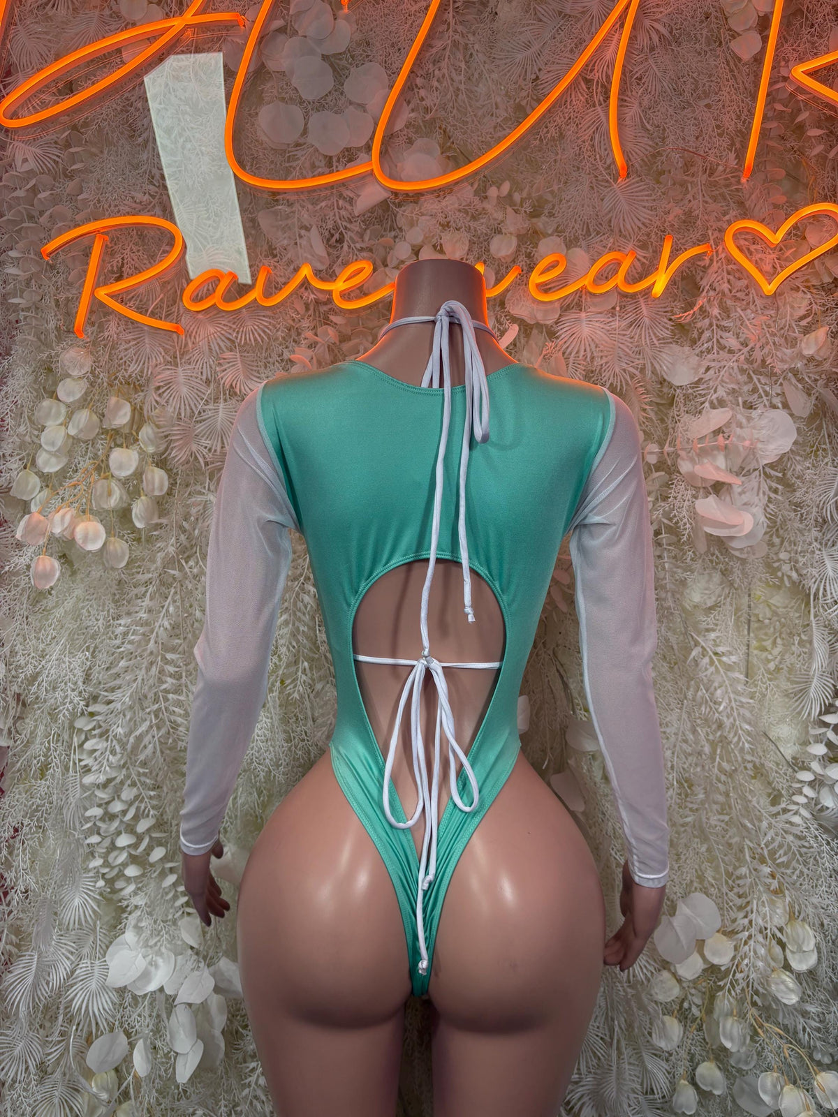 Teal leopard-print bodysuit with open back and white tie straps, long sleeves