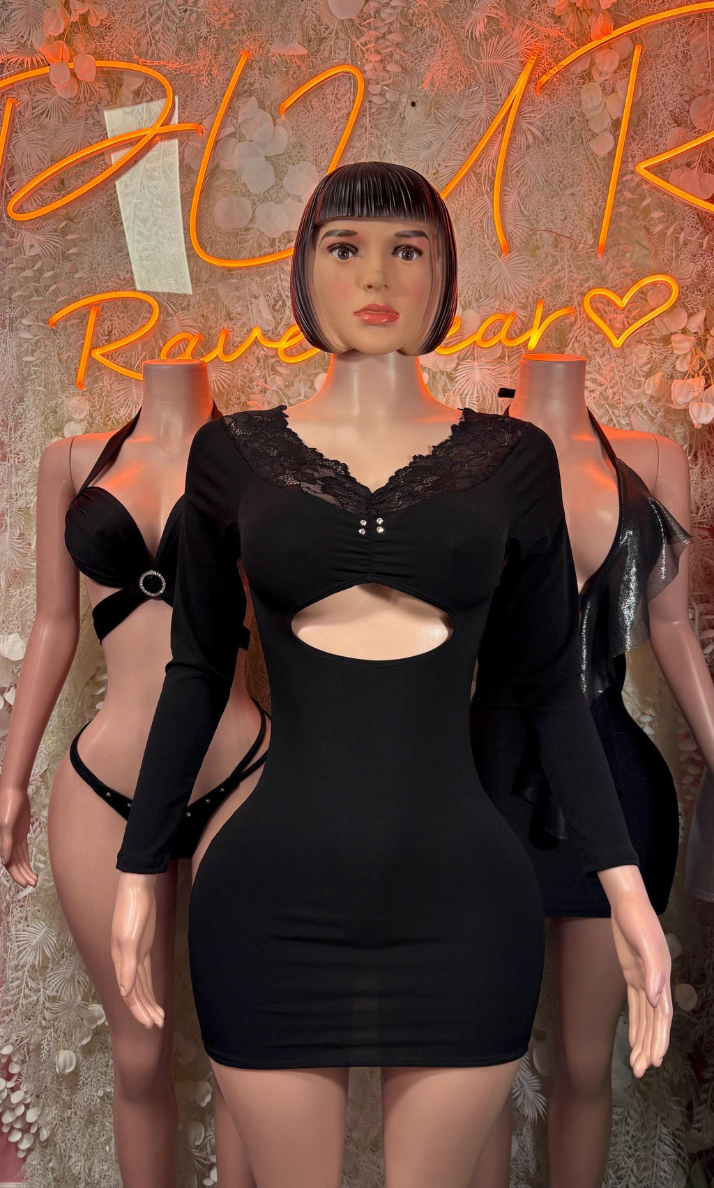 Black mini bodysuit dress with lace trim, long sleeves, and open shoulders
