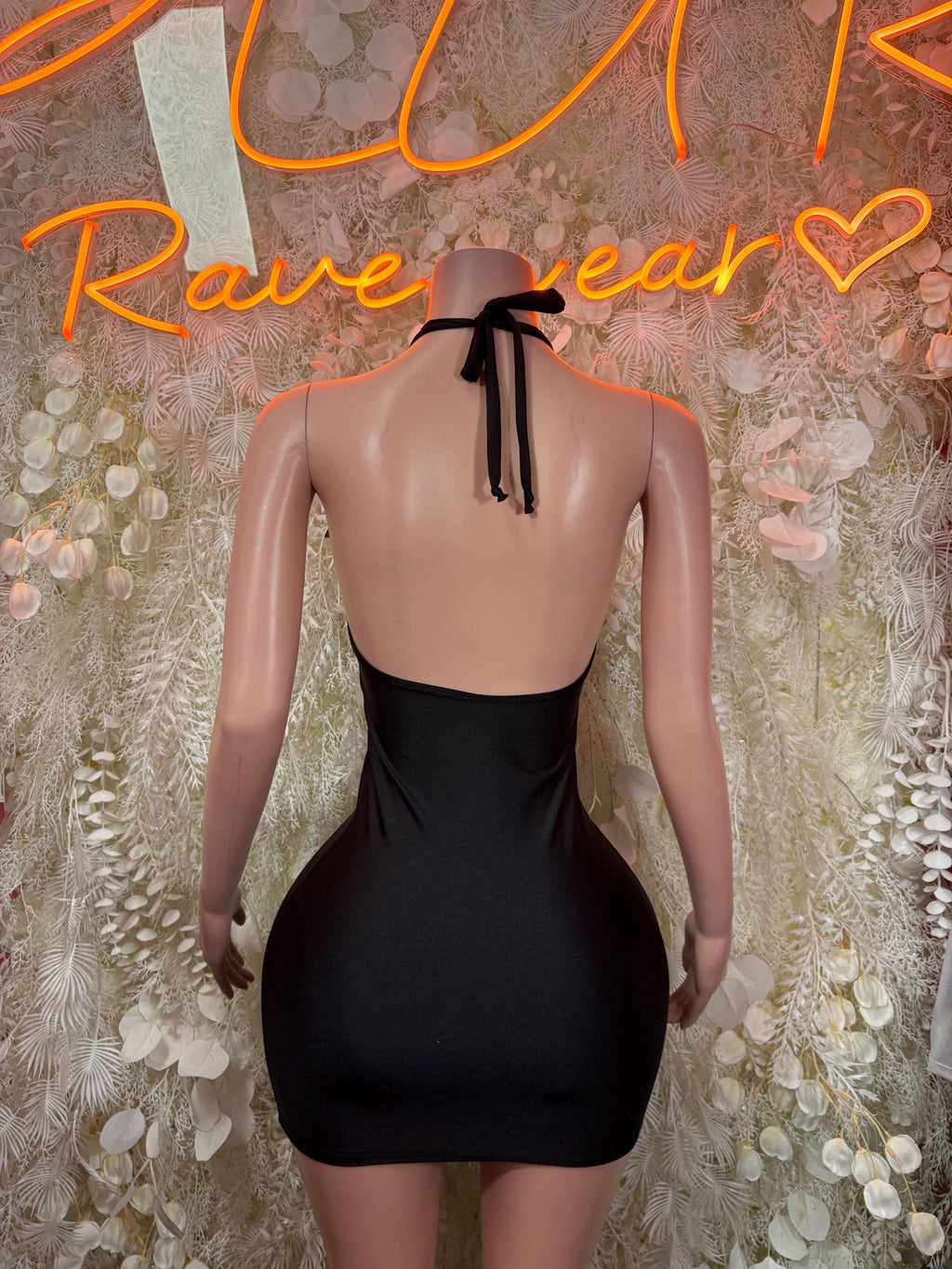 Black backless mini dress with halter tie-back and smooth fitted silhouette