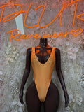 Orange one-piece bodysuit with deep V neckline and thin straps on mannequin
