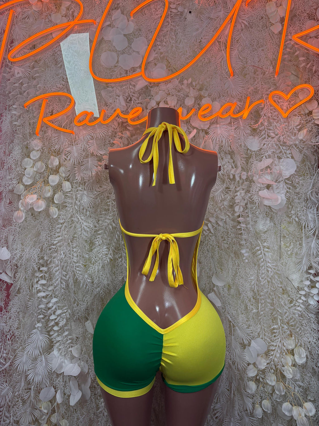 Green and yellow lace-up bodysuit with crisscross ties, halter neckline, high-cut shorts