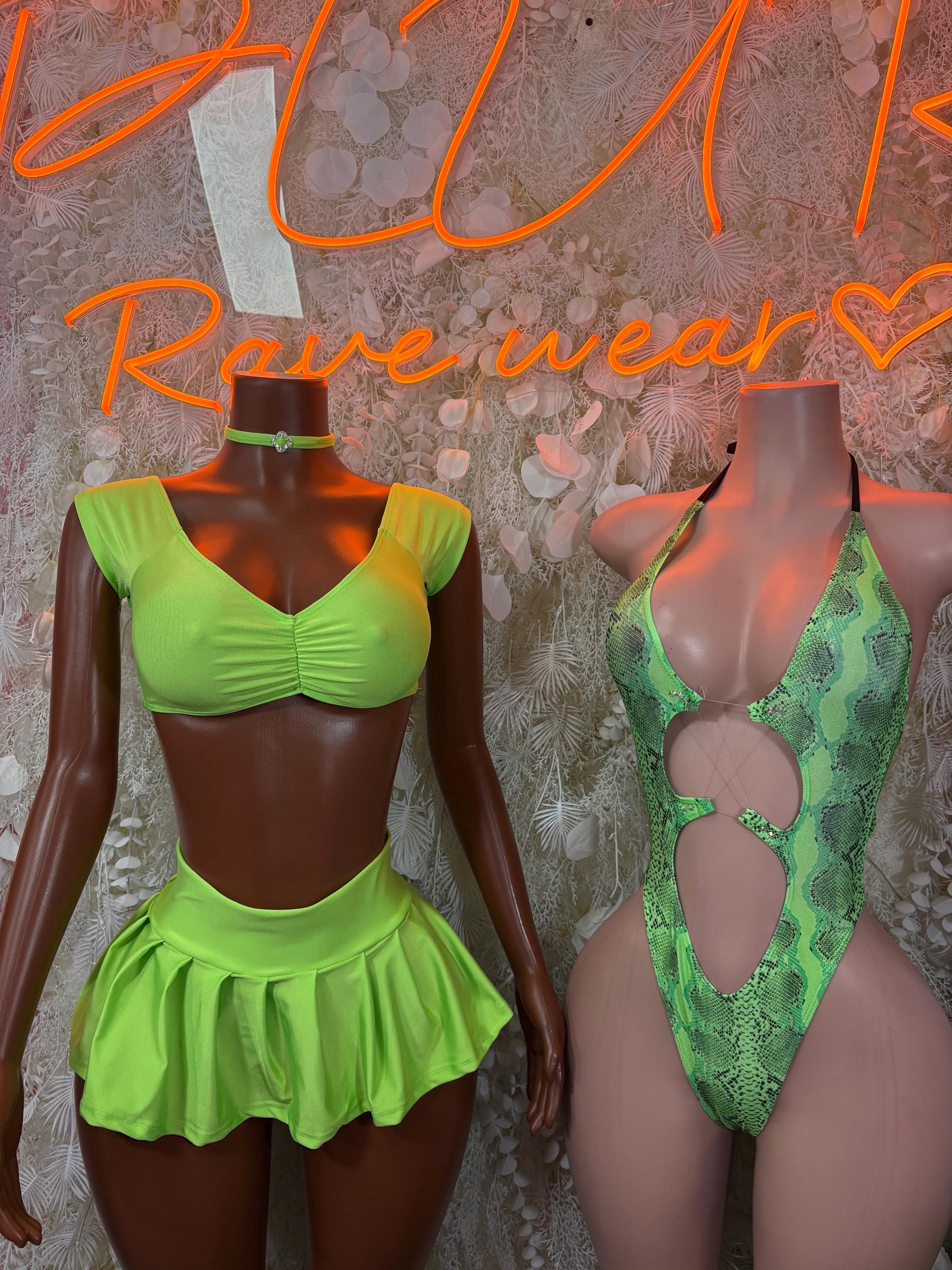 Neon green crop top and pleated mini skirt set with ruched front; green snakeskin swimsuit beside