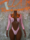 Pink long-sleeve bodysuit with scoop neckline and snap-button front, ruffled bust