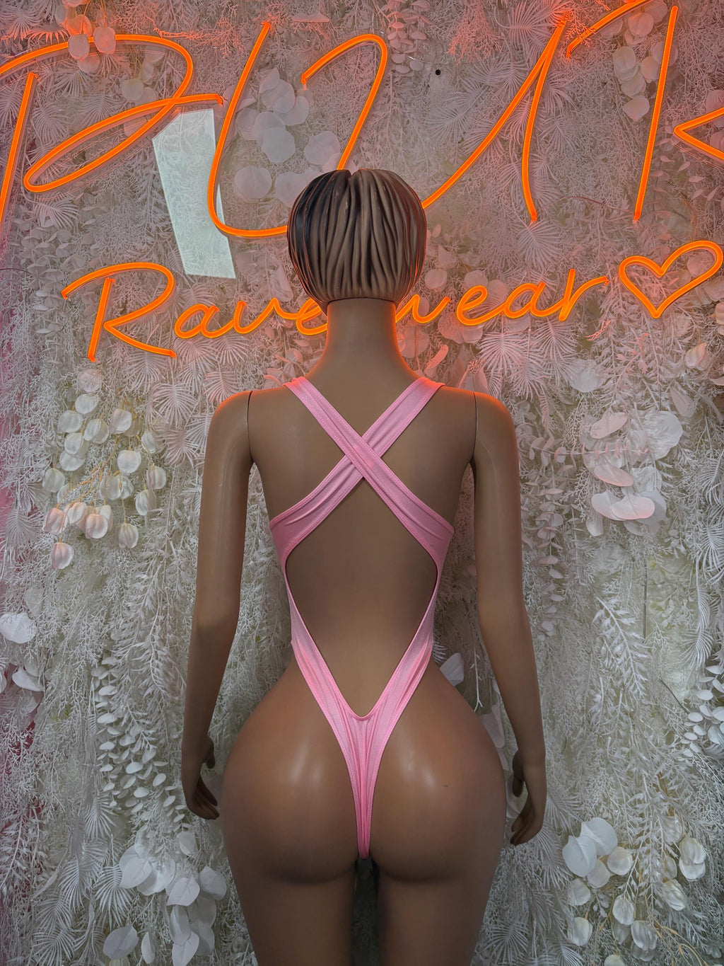 Baby pink one-piece dance bodysuit with crisscross back straps and tie detail