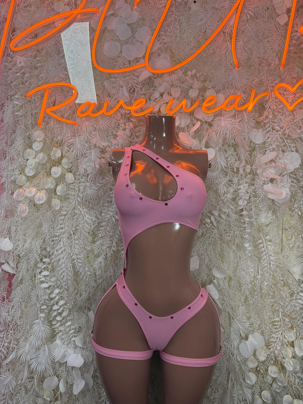 Pink festival bodysuit with halter neckline, cutouts, and thong back.