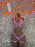 Pink festival bodysuit with halter neckline, cutouts, and thong back.