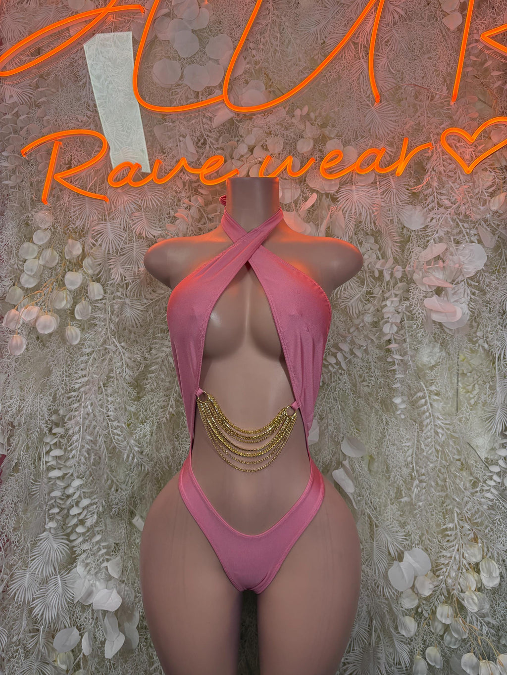 Pink halter bodysuit with open back and crisscross straps, chain tassel detail