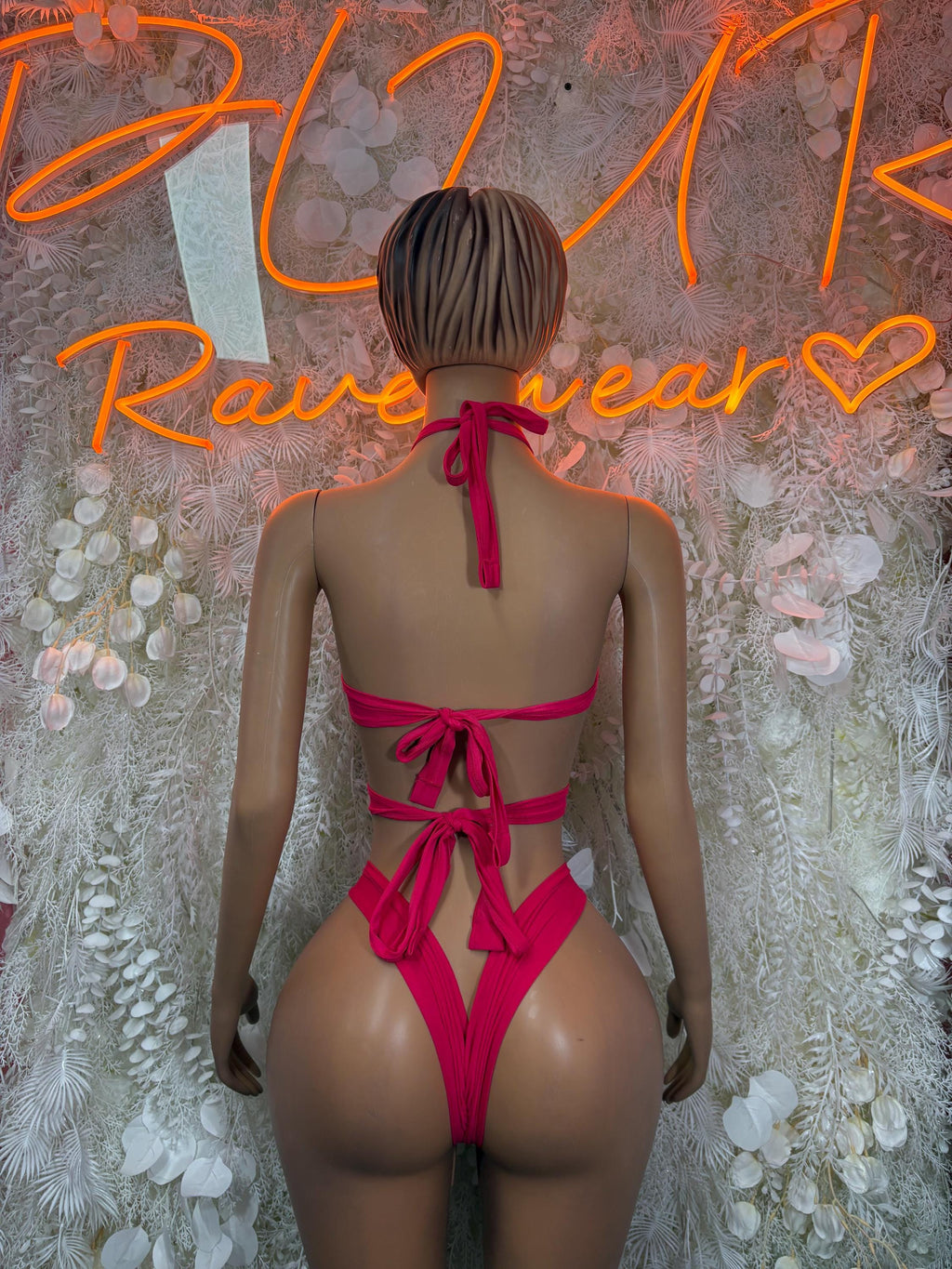 Pink halter-back one-piece bodysuit with lace-up straps and bow ties