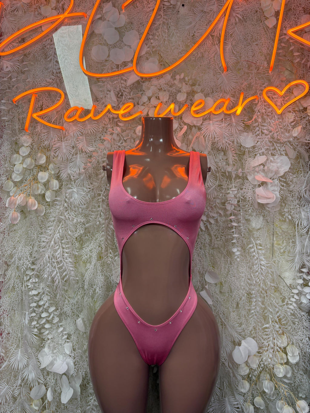 Pink one-piece bodysuit with scoop neckline and high-cut leg openings.