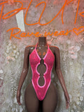 Pink halter one-piece bodysuit with circular cutout detail at center