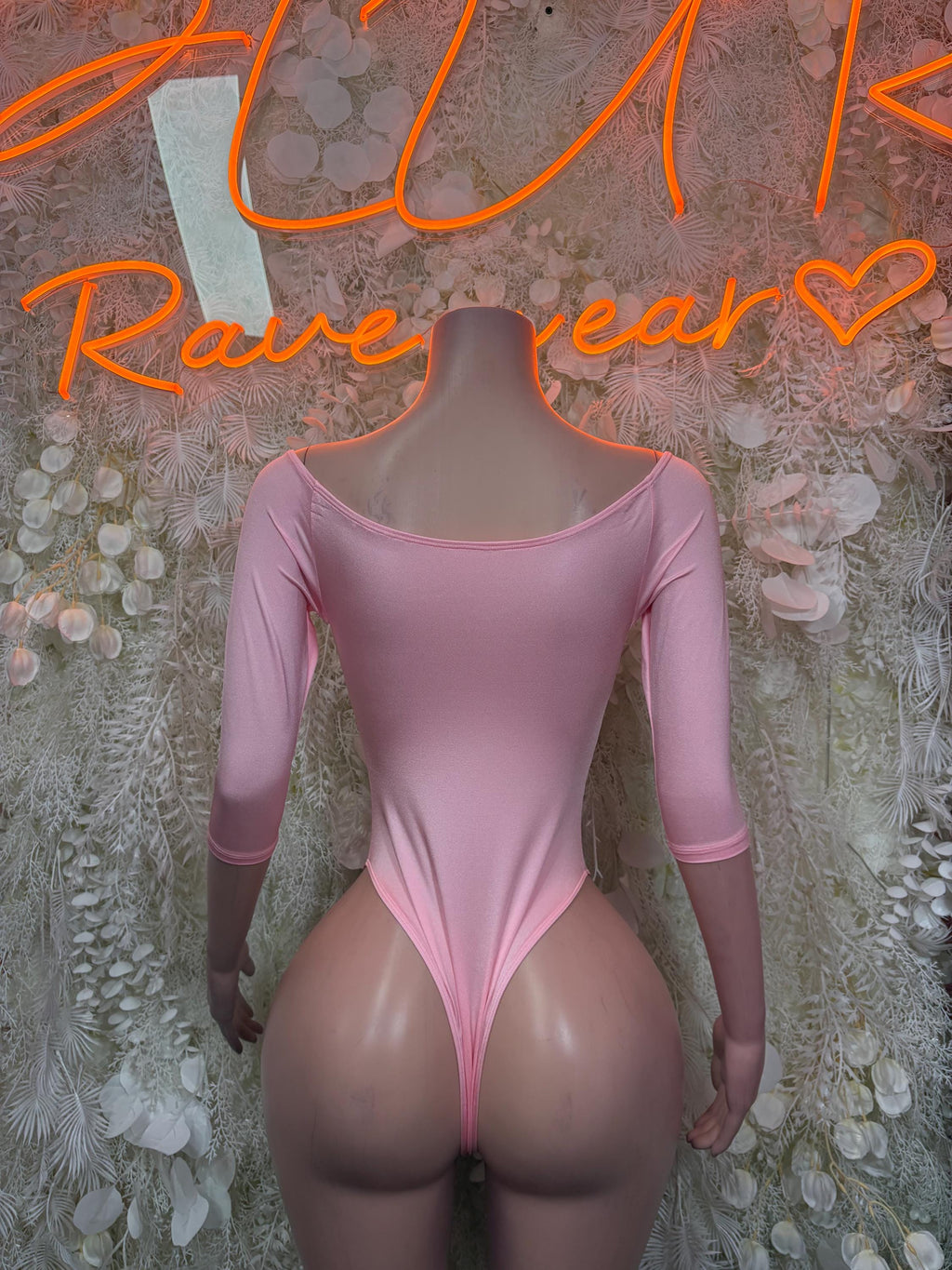 Pink long-sleeve one-piece bodysuit with scooped back and thong-style bottom