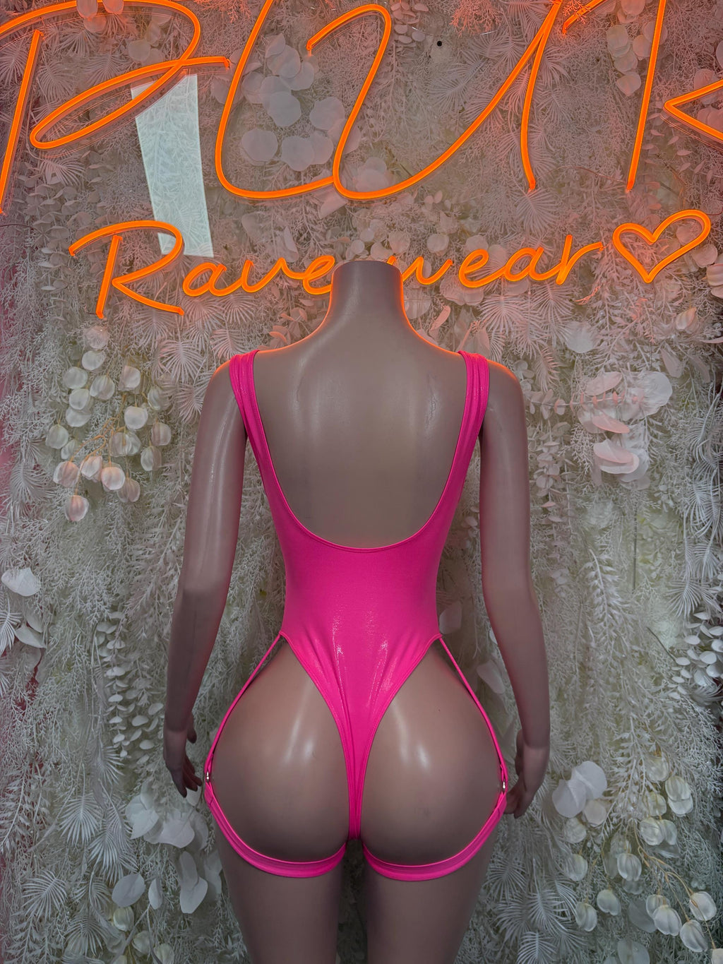 Pink one-piece bodysuit back view with narrow straps and high-cut legs