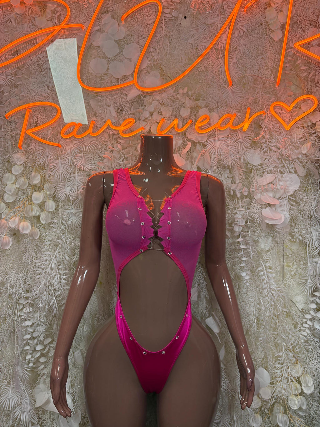 Pink one-piece bodysuit with sheer sleeves and button-front detail