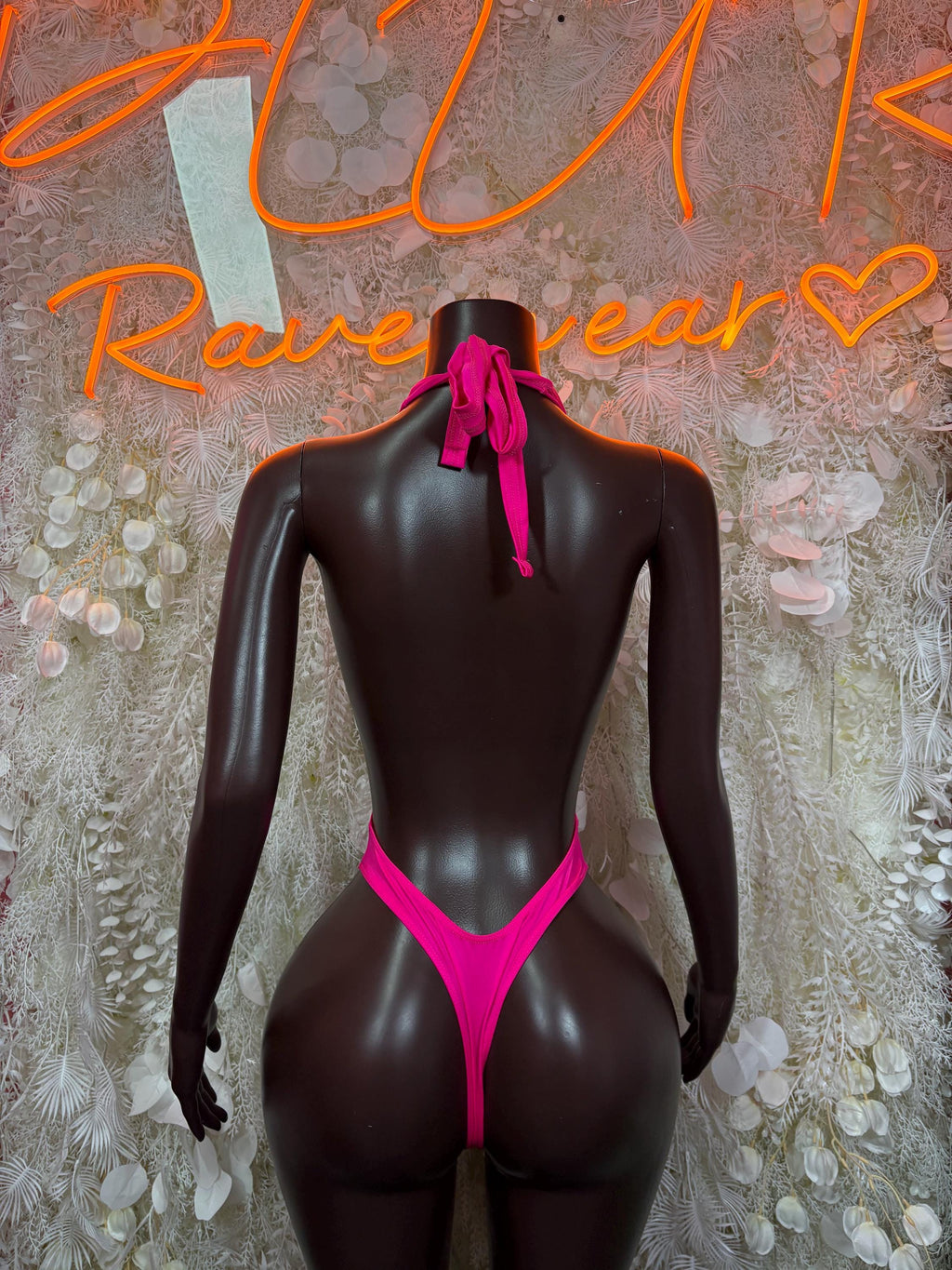 Pink one-piece bodysuit back view with open cutout and tie at neck