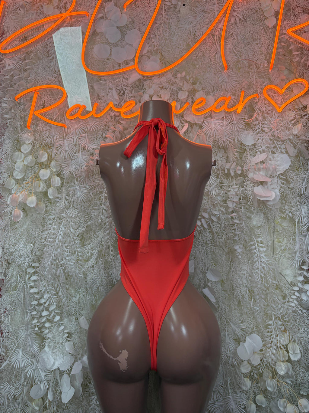 Orange one-piece bodysuit with open back and tie at neckline