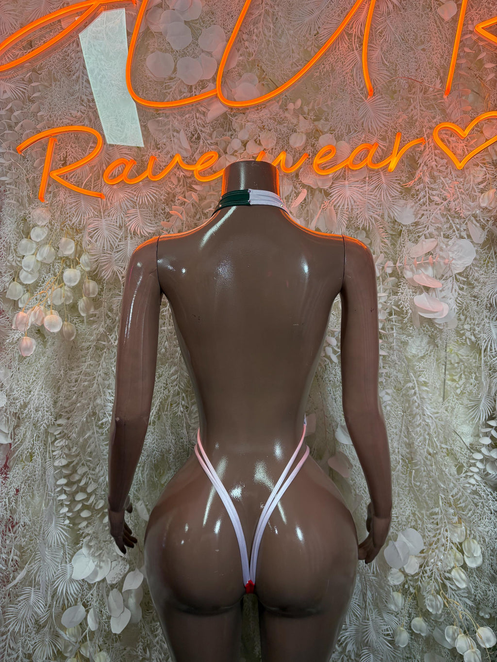 One-piece swimsuit back view with green and red side panels and thin white strap lines