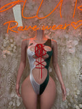Green and white one-piece bodysuit with red lace-up front and high-cut sides