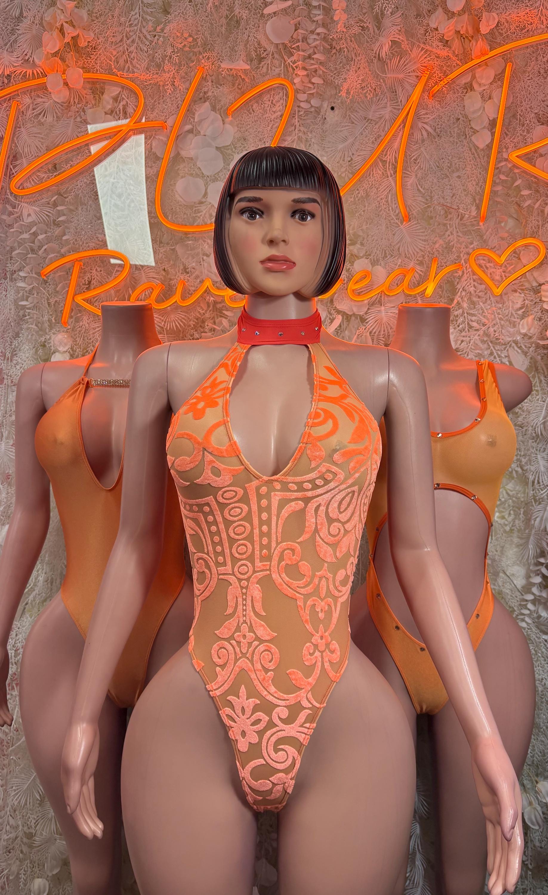 Orange lace-patterned one-piece bodysuit with high collar and front cutout