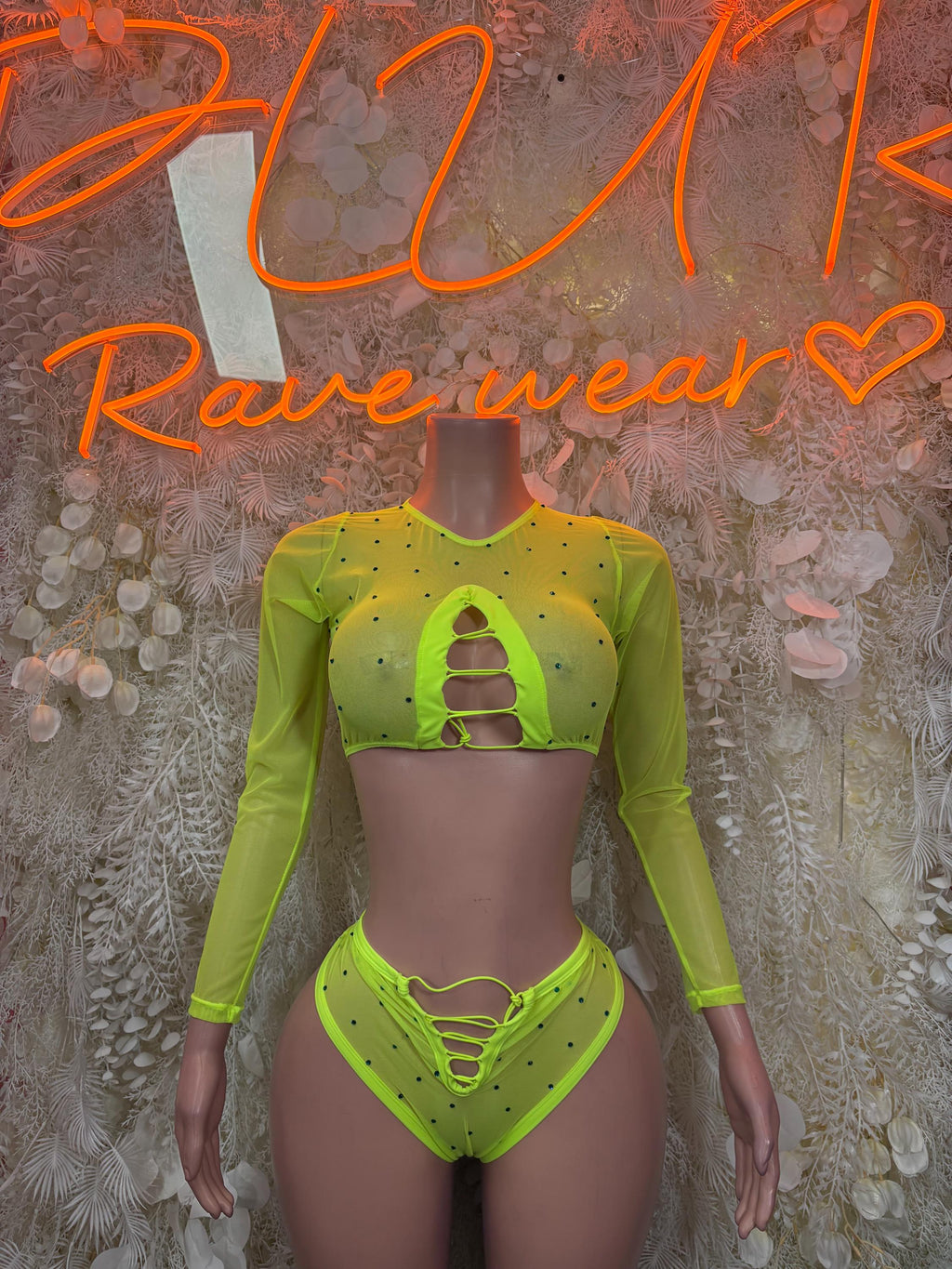 Neon lime green two-piece rave outfit: cropped long-sleeve top and high-cut bottoms.