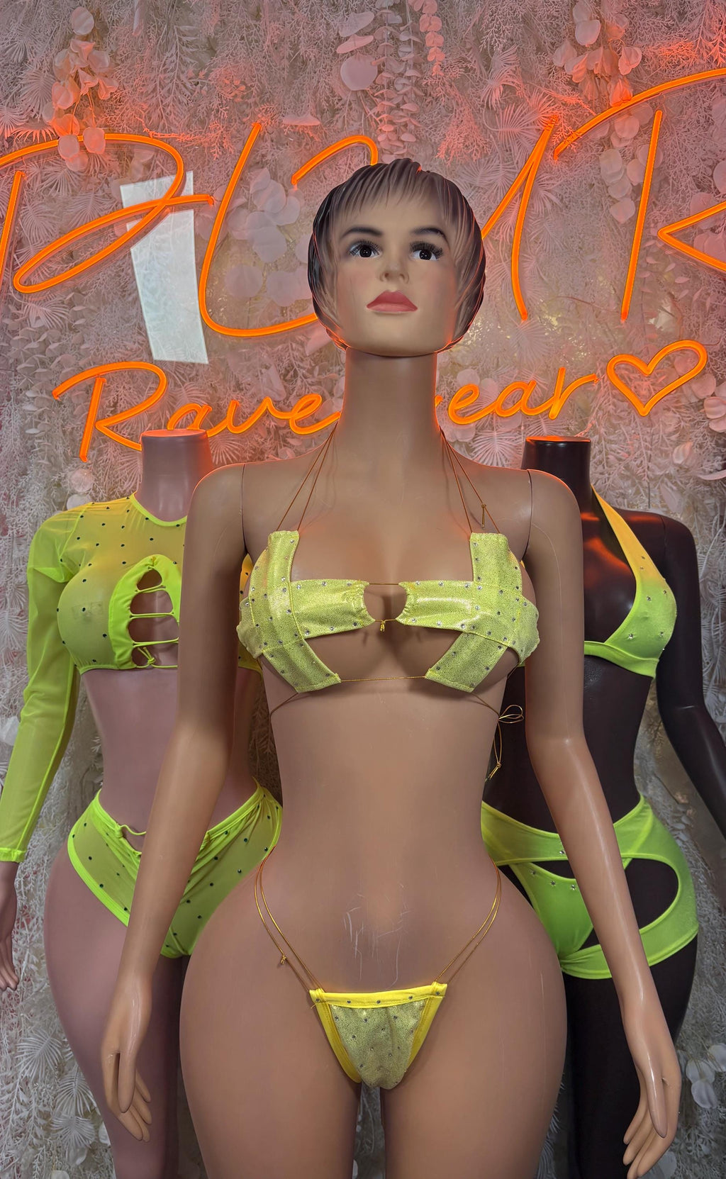 Neon green ravewear set with cropped top, strappy bottoms, and arm sleeves on model
