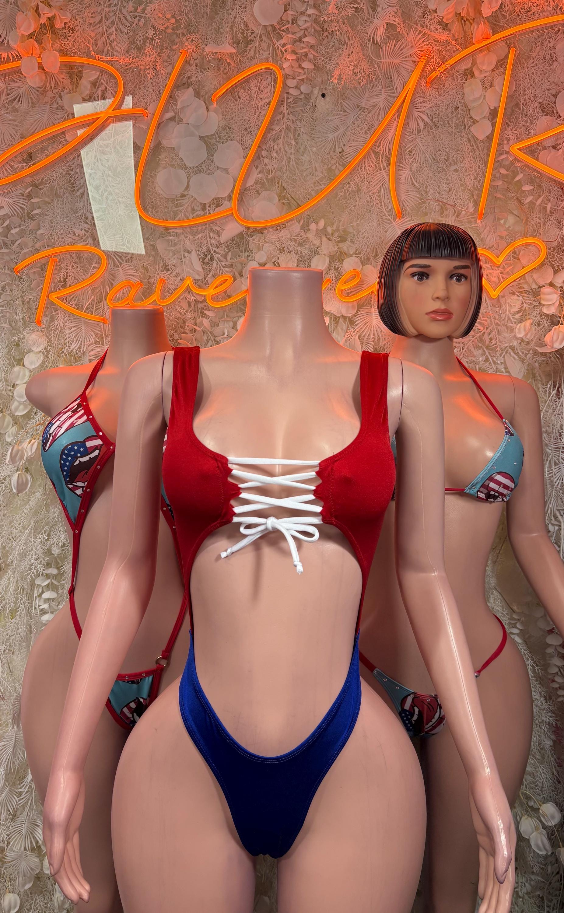 One-piece swimsuit with red bust panel, white lace-up ties, and blue high-leg bottom